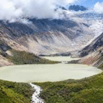 Aerial view of a high-altitude glacial lake nestled in the green Himalayan mountains of Bhutan.