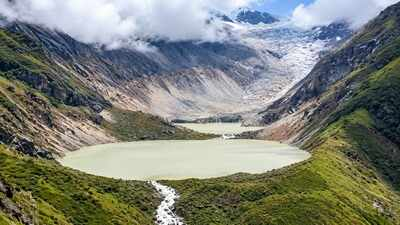 Aerial view of a high-altitude glacial lake nestled in the green Himalayan mountains of Bhutan.