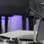 Professional television camera on tripod in briefing room representing a multimedia news agency